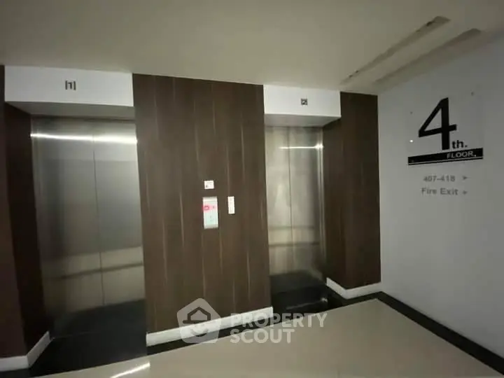 Modern elevator lobby on the 4th floor with sleek design and clear signage.