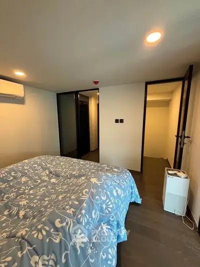 Cozy bedroom with modern decor and air conditioning, featuring a stylish bedspread and sleek flooring.