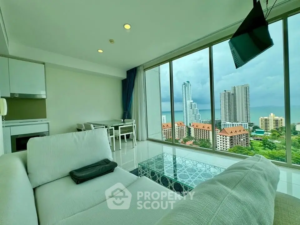 Luxurious living room with stunning city and ocean view, modern furniture, and floor-to-ceiling windows.