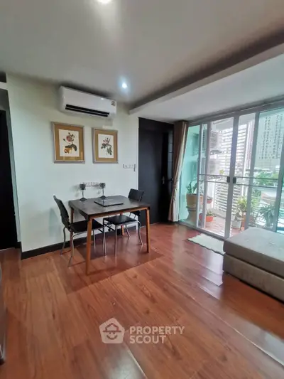 Modern living room with wooden flooring and balcony view in urban apartment