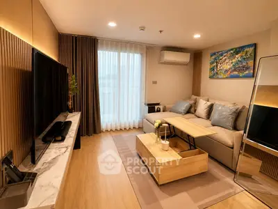 Modern living room with stylish decor, large TV, and cozy seating area in a contemporary apartment.