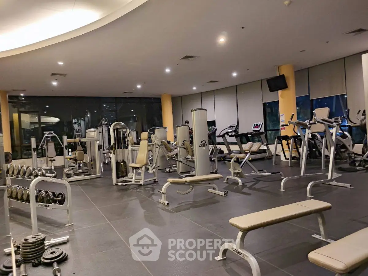 Spacious modern gym with state-of-the-art equipment in luxury residential building.