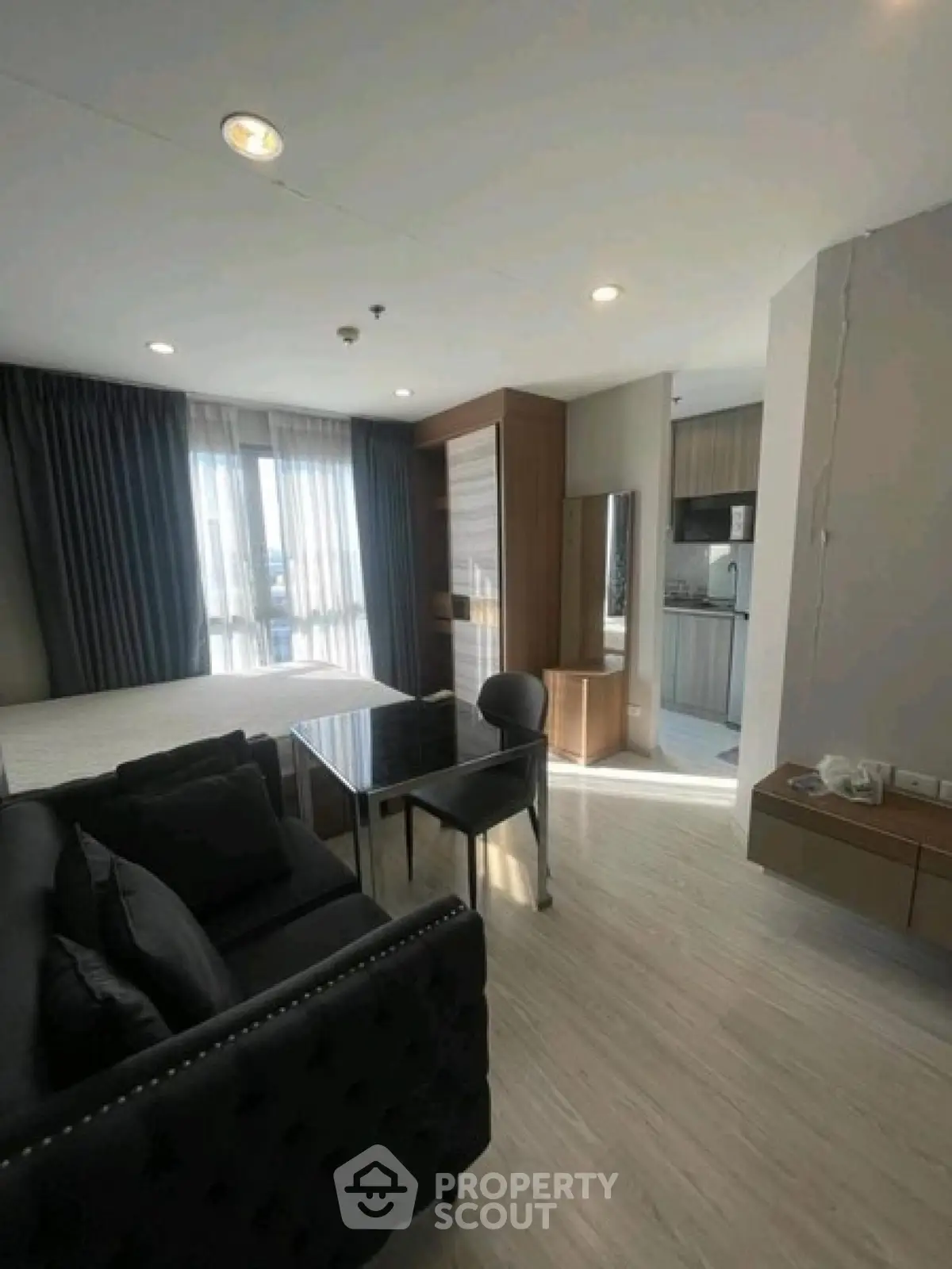 Modern studio apartment with open layout, featuring a cozy living area and stylish kitchen.