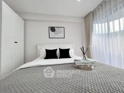 Modern minimalist bedroom with cozy bedding and natural light