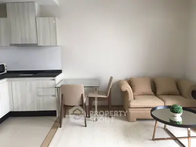 Modern open-layout living room with sleek kitchen and cozy seating area.