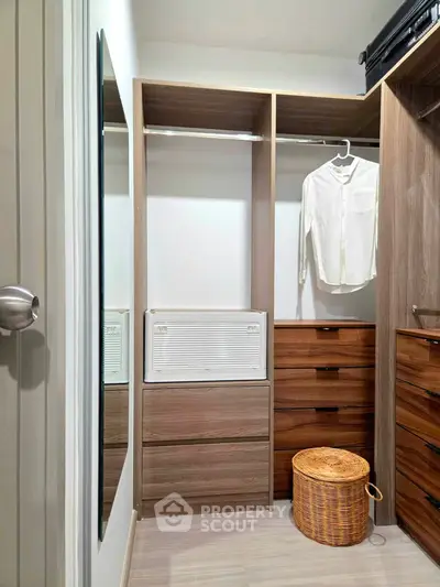 Spacious walk-in closet with modern wooden cabinetry and ample storage space.