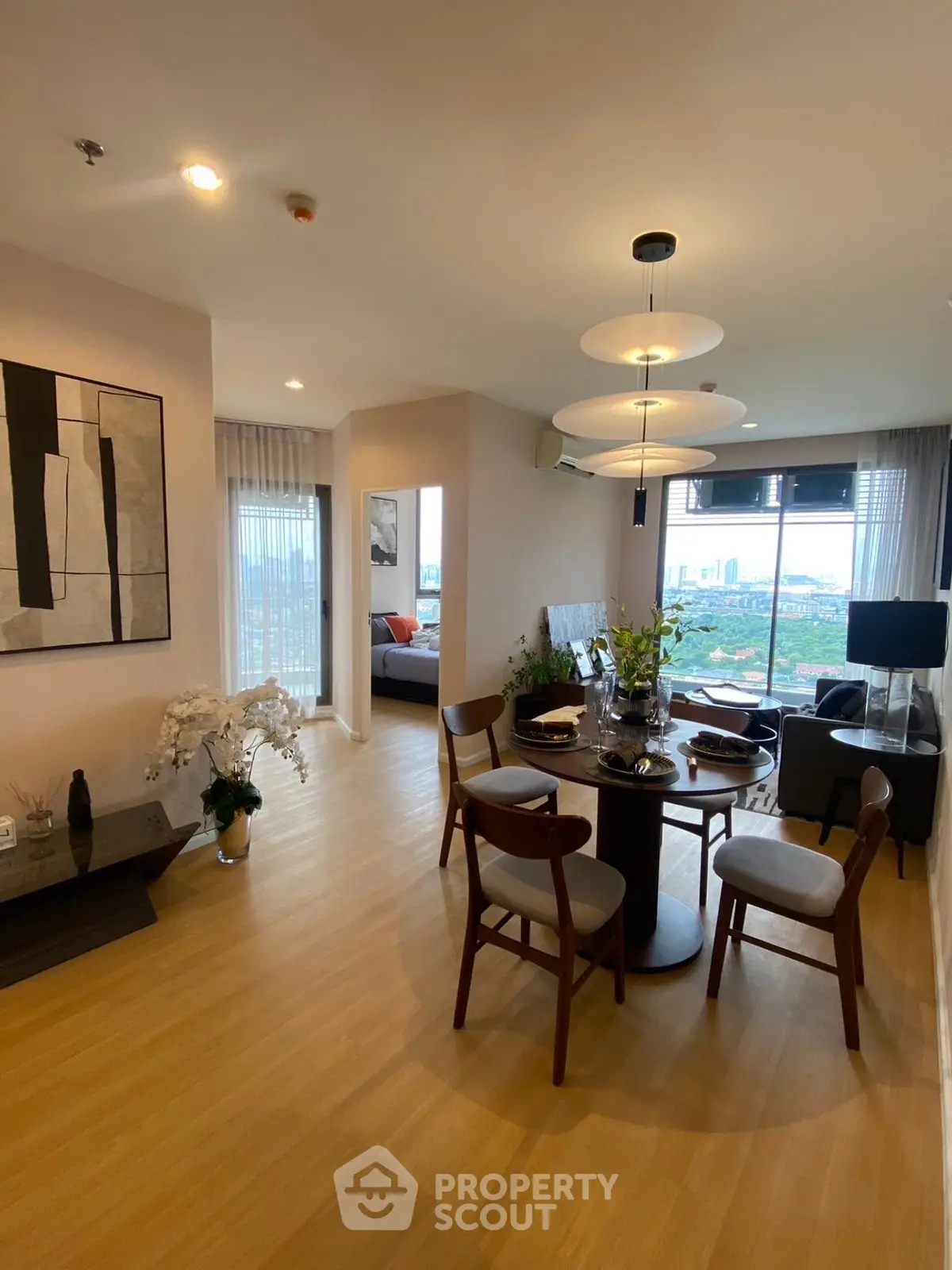 Modern open-plan living and dining area with stylish decor and city view.