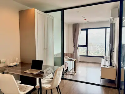 Modern apartment interior with open layout and city view, featuring a stylish workspace and cozy living area.