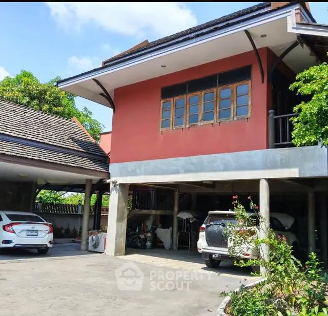 Charming two-story house with spacious carport and lush greenery, perfect for family living.