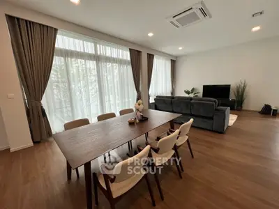 Spacious modern living room with elegant dining area and large windows.