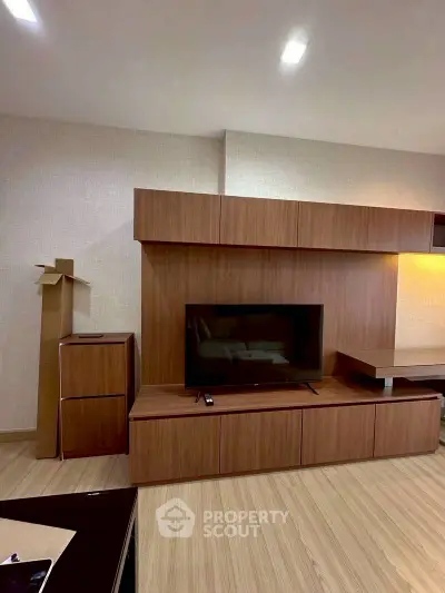 Modern living room with sleek wooden entertainment center and flat-screen TV