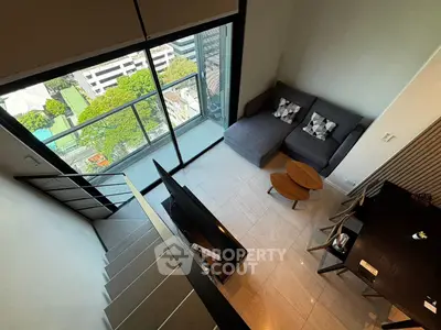 Modern loft apartment with mezzanine, large windows, and city view balcony.