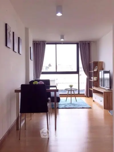 Modern living room with large window, stylish furniture, and wooden flooring in a cozy apartment.
