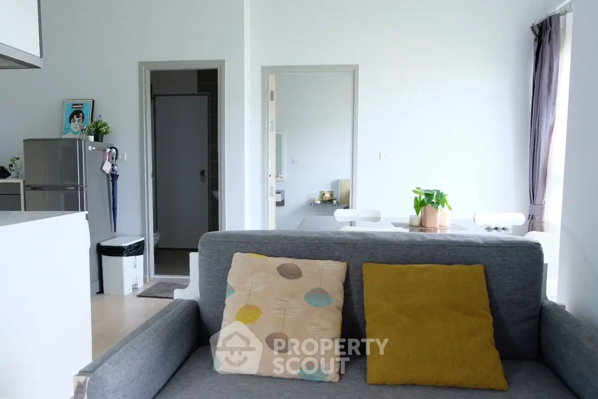 Modern living room with stylish sofa and dining area, bright and inviting space.