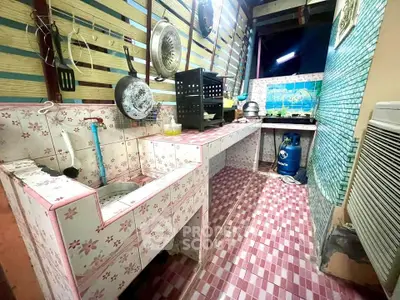 Charming rustic kitchen with floral tiles and open layout, featuring a gas stove and ample storage space.