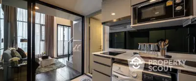 Modern apartment with sleek kitchen and cozy living area, featuring washing machine and microwave.