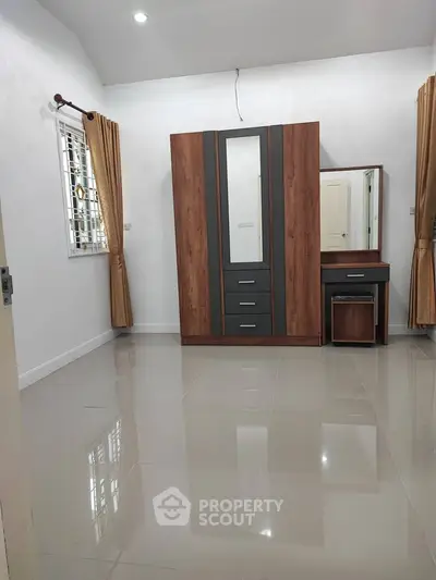 Spacious bedroom with sleek wardrobe and vanity, featuring glossy tiled floors and elegant curtains.