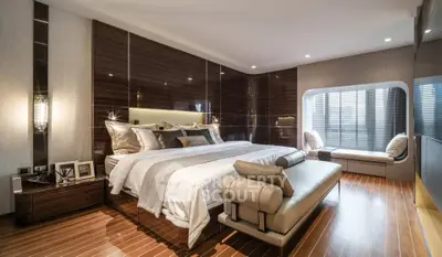 Luxurious modern bedroom with elegant decor and cozy seating area.