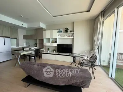 Modern open-plan living room with stylish furniture and large windows in a contemporary apartment.