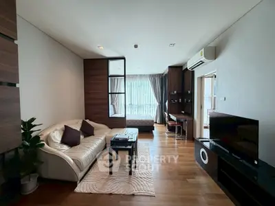 Modern living room with cozy sofa, TV, and stylish decor in open-plan apartment.