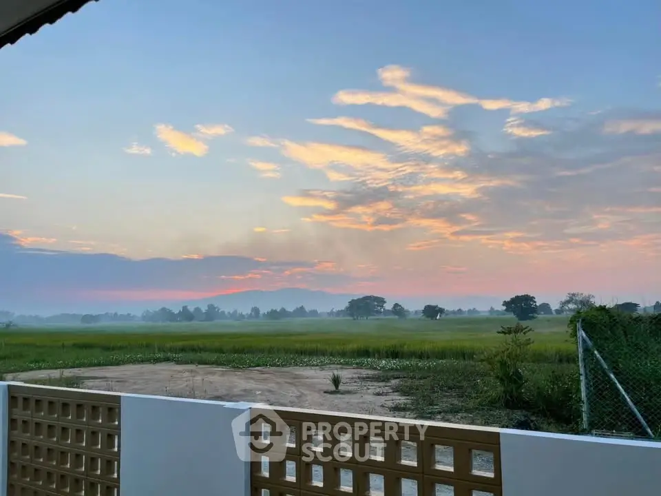 Stunning countryside view from a modern property with open skies and lush greenery.