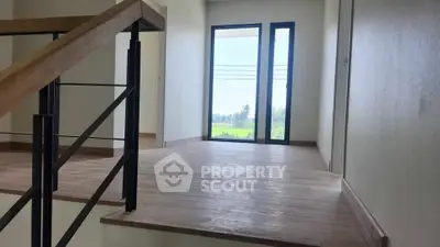 Spacious hallway with large window offering scenic views, perfect for modern living.