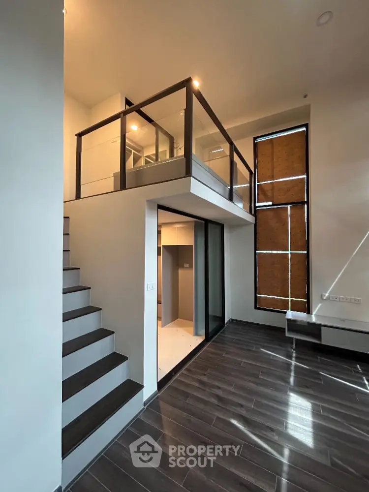 Modern duplex interior with sleek staircase and high ceilings