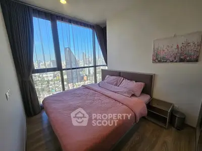 Modern bedroom with city view and stylish decor in high-rise apartment.