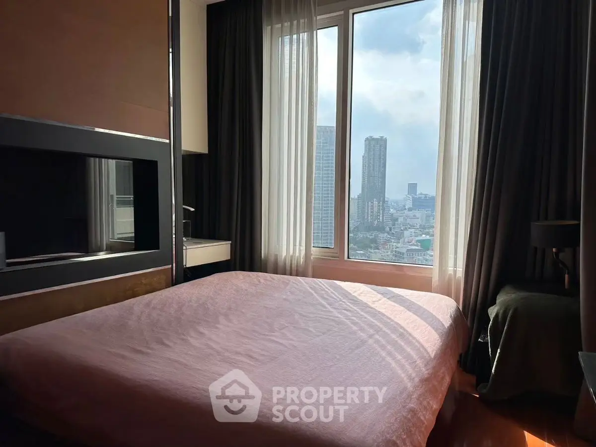 Spacious bedroom with large window offering stunning city view, perfect for urban living.