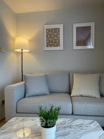 Modern living room with stylish gray sofa, elegant decor, and cozy lighting.