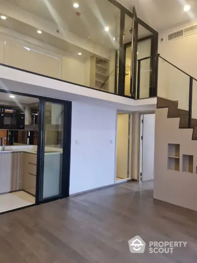 Modern duplex apartment with high ceilings, sleek kitchen, and stylish staircase leading to an airy loft space, perfect for urban living.