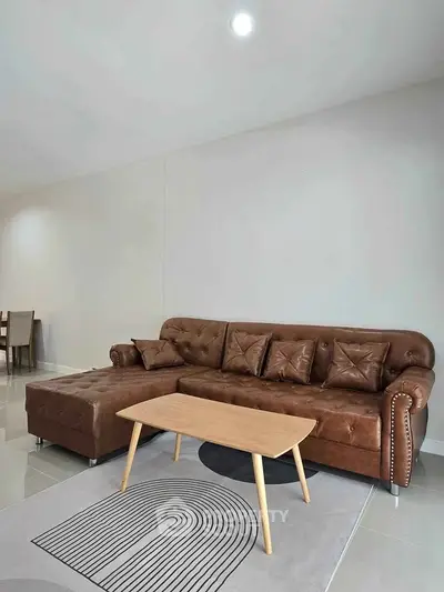 Stylish living room with brown leather sofa and modern wooden coffee table.