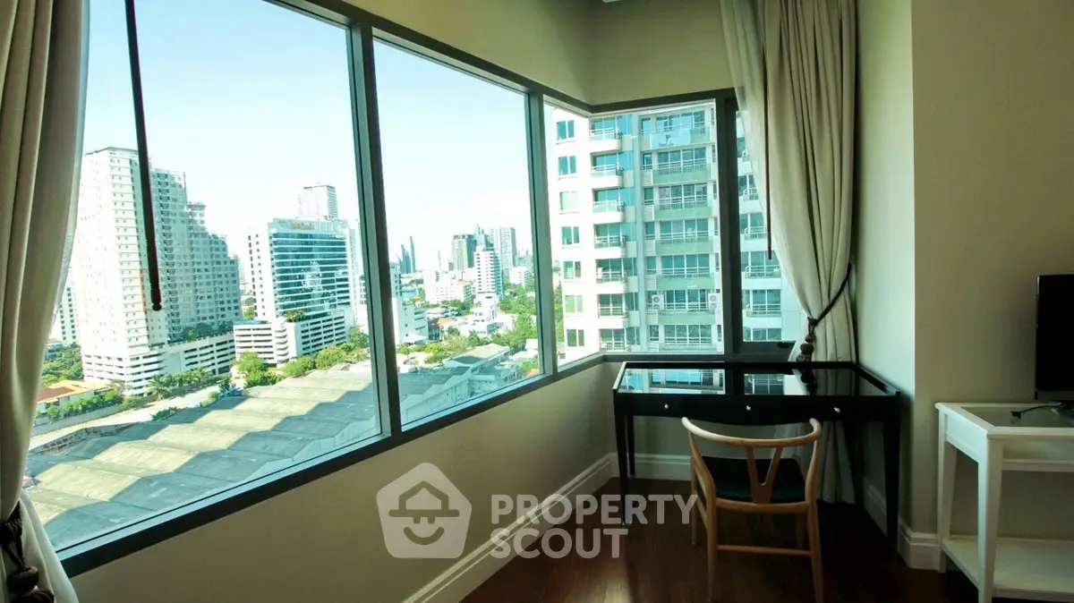 Stunning corner unit with panoramic city views from a stylish study area.