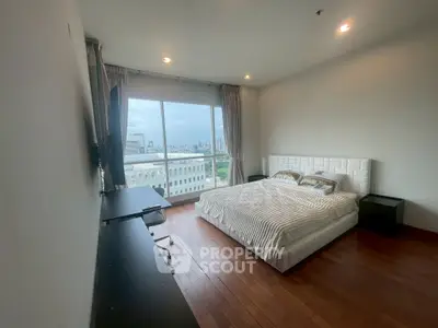 Spacious bedroom with city view, featuring a large bed and modern furnishings, perfect for urban living.