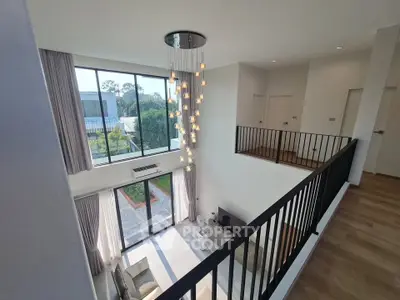 Stunning modern duplex with high ceilings and elegant chandelier, offering a spacious and bright living area.