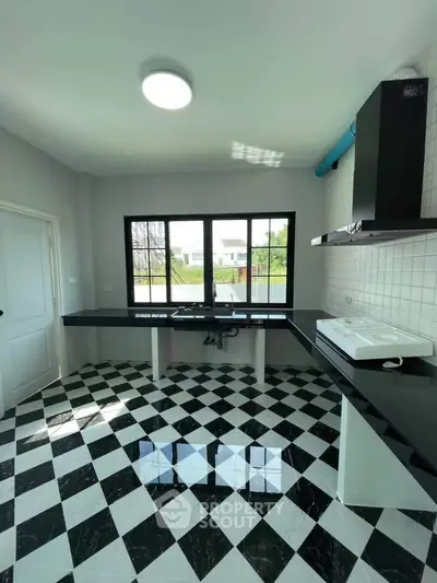 Modern kitchen with black and white checkered floor and sleek countertops