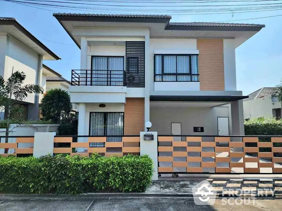 Modern two-story house with stylish facade and gated entrance in a suburban neighborhood.