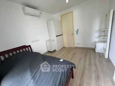 Cozy bedroom with wooden flooring and modern air conditioning unit