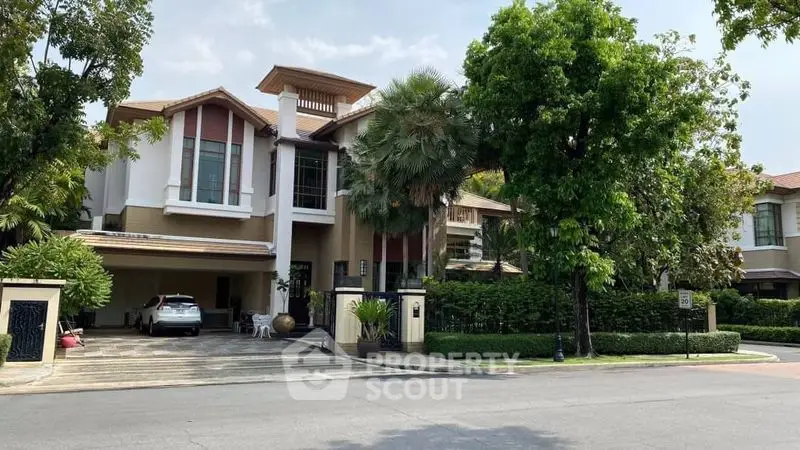 Luxurious modern house with lush greenery and spacious driveway in a serene neighborhood.