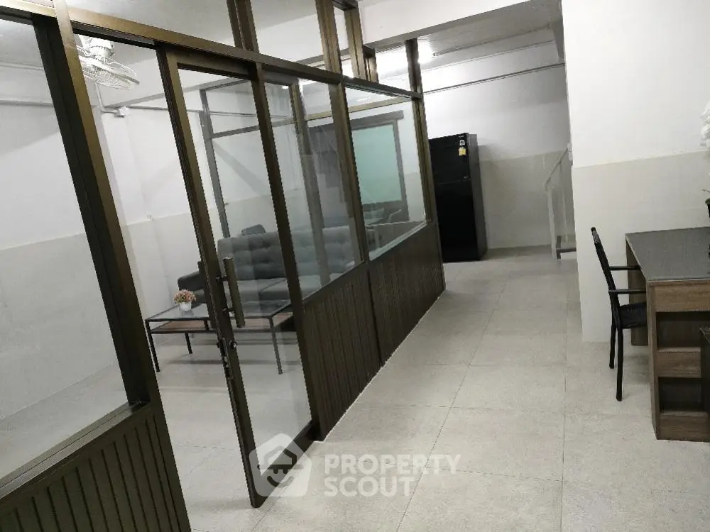 Spacious modern living area with glass partition and sleek furniture