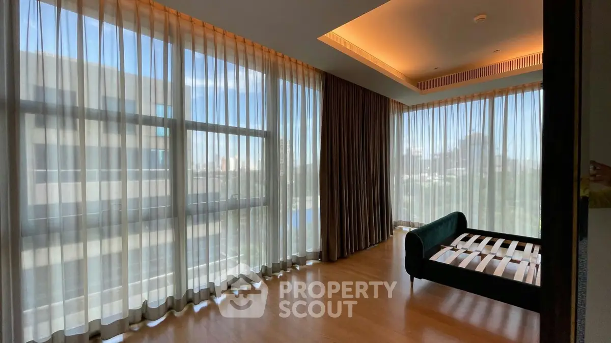 Spacious corner unit with floor-to-ceiling windows and elegant hardwood flooring.