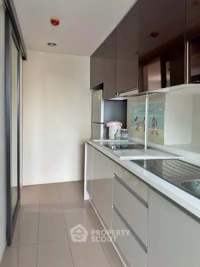Modern kitchen with sleek cabinetry and stainless steel appliances in a compact layout.