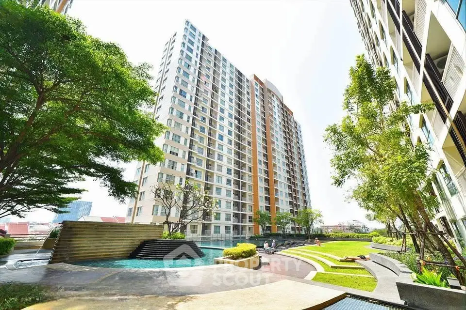 Modern high-rise apartment building with lush garden and pool area, perfect for urban living.