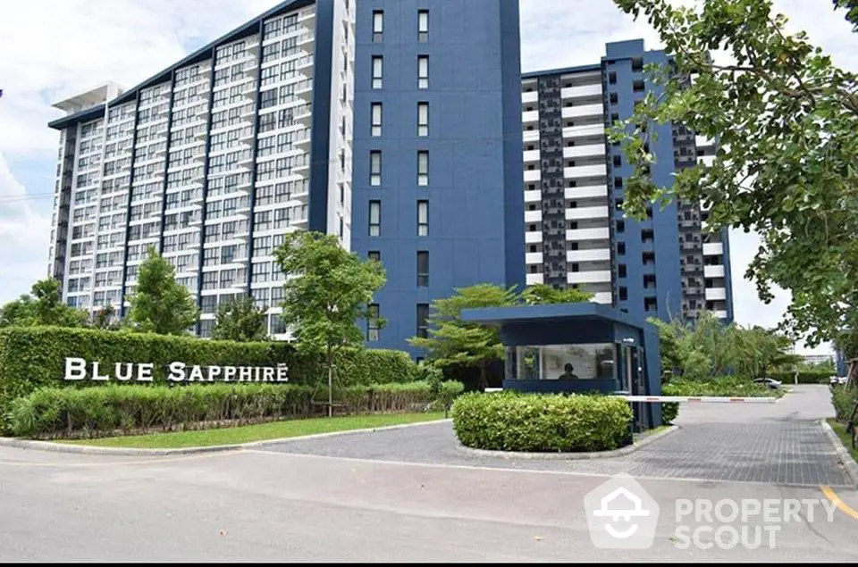 Modern high-rise residential building with lush greenery and secure entrance at Blue Sapphire.