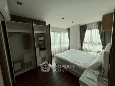 Spacious bedroom with large windows and modern furnishings, perfect for natural light lovers.