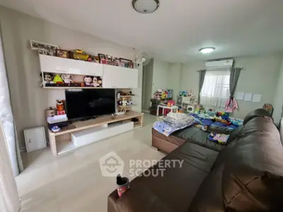 Spacious living room with modern entertainment center and cozy seating area.