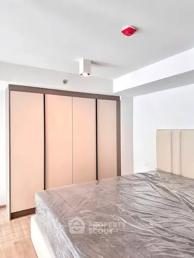 Modern bedroom with sleek wardrobe and bed in a minimalist design.