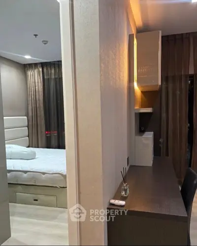 Modern bedroom with sleek furniture and ambient lighting, featuring a comfortable bed and stylish desk area.