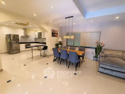 Spacious open-plan living and dining area with modern kitchen and elegant decor.