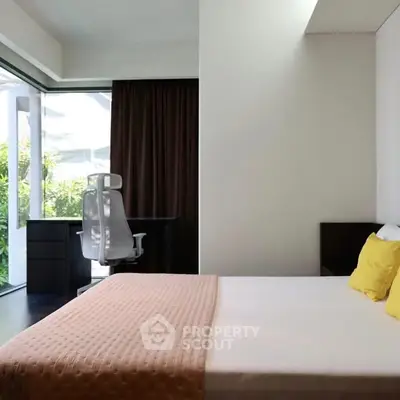 Modern bedroom with large window and study area, featuring stylish decor and natural light.